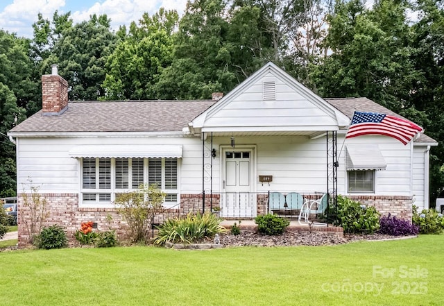 409 E 18th St, Kannapolis, NC 28083 - view of front of home featuring a chimney, brick siding, a front lawn, covered porch, and roof with shingles