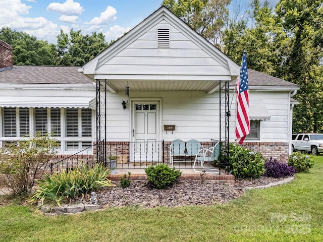 409 E 18th St, Kannapolis, NC 28083 - view of front of property with covered porch, brick siding, a front yard, and roof with shingles