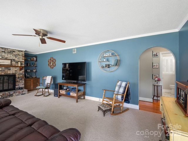 409 E 18th St, Kannapolis, NC 28083 - carpeted living room featuring arched walkways, crown molding, a ceiling fan, and a brick fireplace