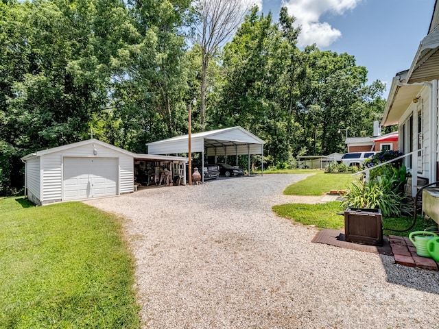 409 E 18th St, Kannapolis, NC 28083 - detached garage with gravel driveway, view of wooded area, and a carport
