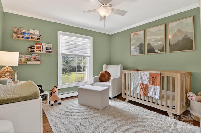 601 Pennell St NE, Lenoir, NC 28645 - bedroom with a crib, wood finished floors, ornamental molding, a baseboard heating unit, and a ceiling fan