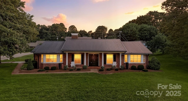 601 Pennell St NE, Lenoir, NC 28645 - ranch-style home with brick siding, a lawn, a porch, and a metal roof