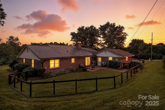 601 Pennell St NE, Lenoir, NC 28645 - back of house featuring brick siding, a patio, a chimney, and a metal roof