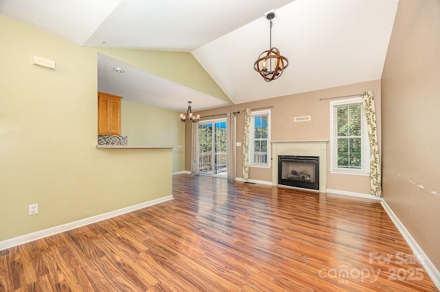 610 Mountain Pl, Albemarle, NC 28001 - unfurnished living room featuring a chandelier, wood finished floors, lofted ceiling, healthy amount of natural light, and a fireplace