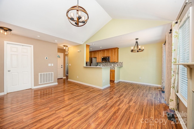 610 Mountain Pl, Albemarle, NC 28001 - unfurnished living room featuring a chandelier, vaulted ceiling, and light wood-type flooring
