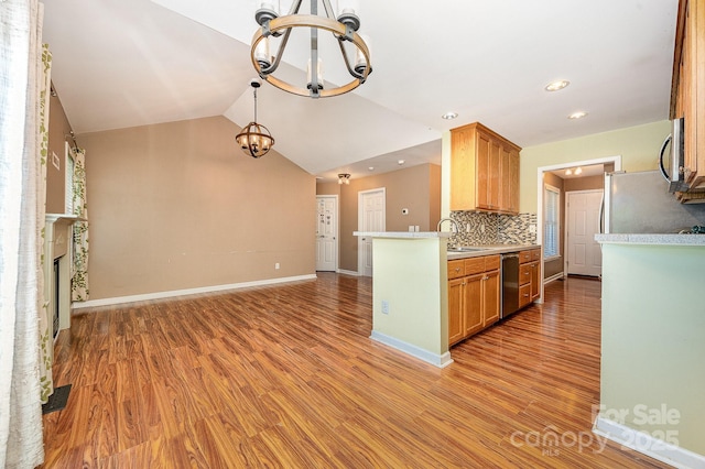 610 Mountain Pl, Albemarle, NC 28001 - kitchen with a chandelier, light wood-style floors, stainless steel appliances, light countertops, and backsplash