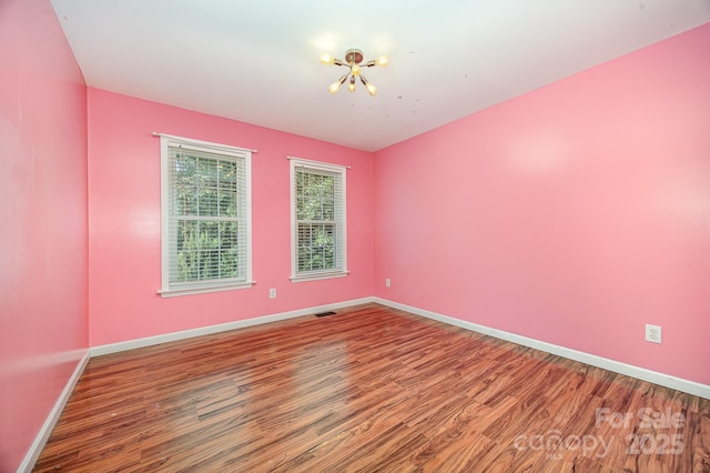 610 Mountain Pl, Albemarle, NC 28001 - unfurnished room with wood finished floors and a chandelier
