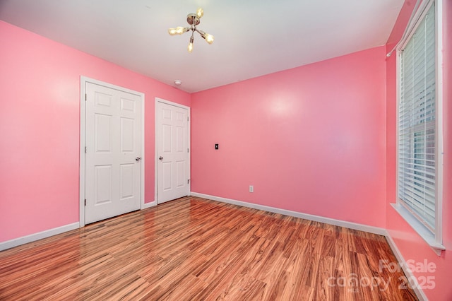 610 Mountain Pl, Albemarle, NC 28001 - unfurnished bedroom with a chandelier and wood finished floors