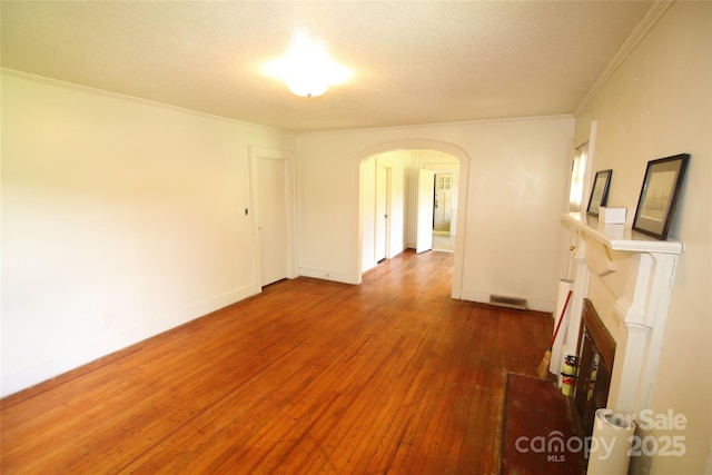 1541 Kings Rd, Shelby, NC 28150 - unfurnished living room with arched walkways, hardwood / wood-style flooring, ornamental molding, and a textured ceiling