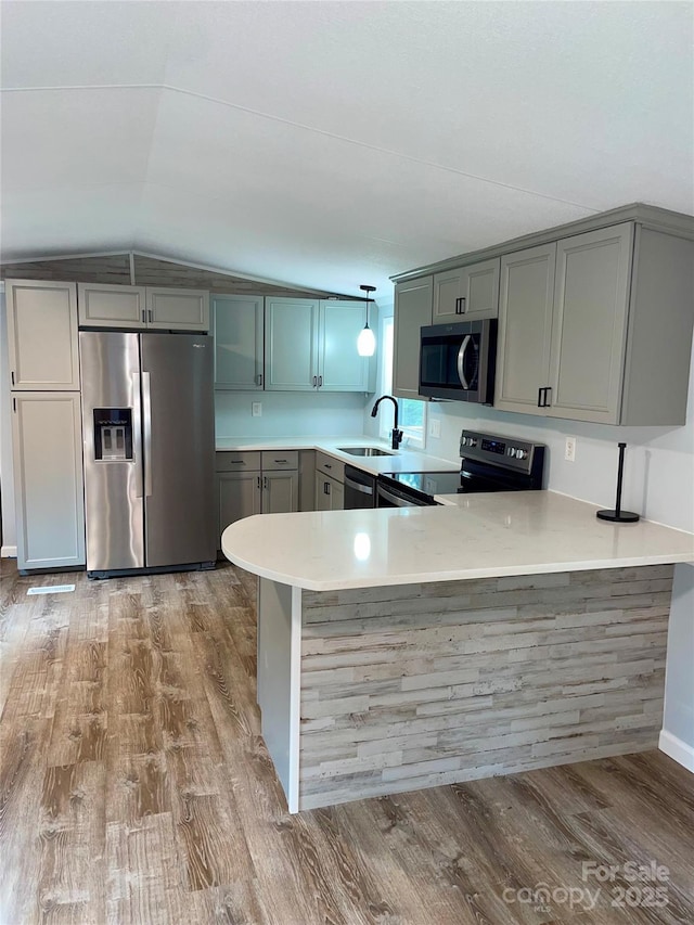 6517 Helens Way, Denver, NC 28037 - kitchen featuring appliances with stainless steel finishes, lofted ceiling, light countertops, a peninsula, and wood finished floors