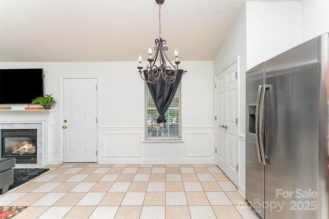 5914 Redding Rd, Charlotte, NC 28216 - unfurnished dining area with a chandelier, a fireplace, wainscoting, and light tile patterned floors