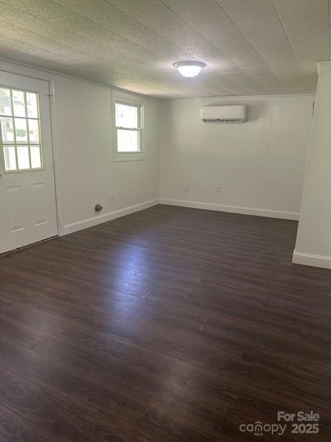 1011 Warren Pl NW, Lenoir, NC 28645 - below grade area featuring an AC wall unit and dark wood-style floors