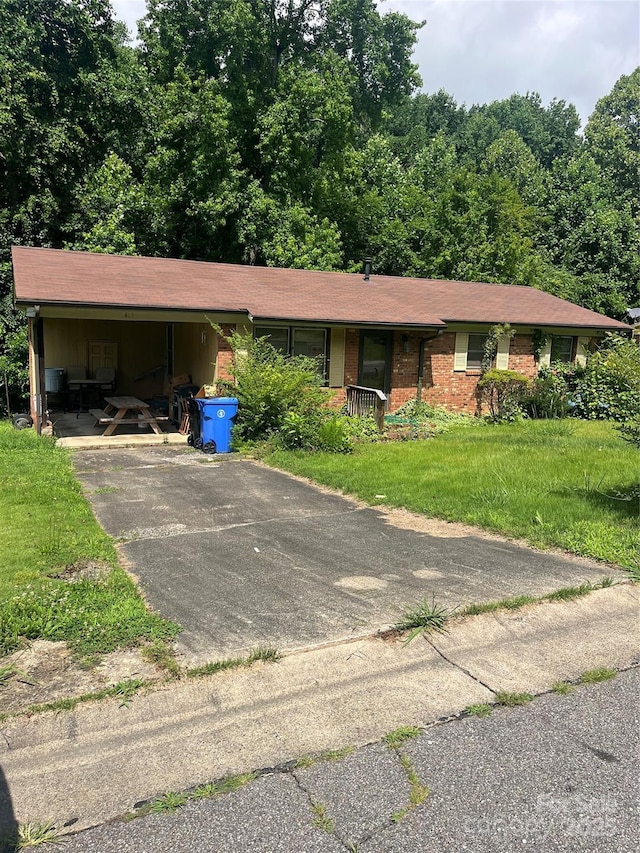 413 Mclelland Ave, Mooresville, NC 28115 - view of front of property with a front lawn, an attached carport, asphalt driveway, and brick siding