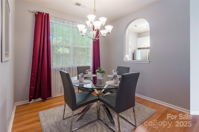14755 Lions Paw St, Charlotte, NC 28273 - dining area featuring a chandelier, light wood finished floors, and arched walkways