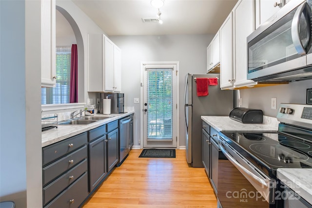 14755 Lions Paw St, Charlotte, NC 28273 - kitchen with appliances with stainless steel finishes, white cabinets, light wood-style flooring, and arched walkways