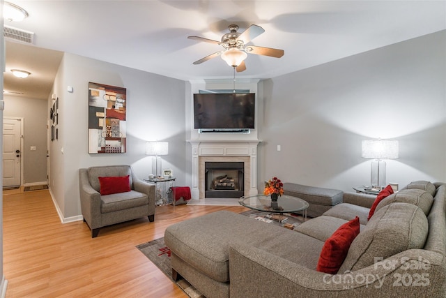 14755 Lions Paw St, Charlotte, NC 28273 - living area featuring ceiling fan, a fireplace with flush hearth, and light wood-style flooring