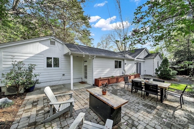 2314 Wolfe St, Charlotte, NC 28205 - back of property featuring outdoor dining area, a patio, and a shingled roof