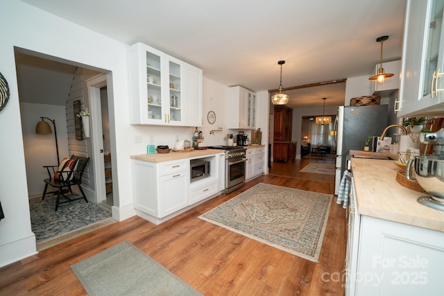 1712 Umstead St, Charlotte, NC 28205 - kitchen with stainless steel appliances, wood finished floors, light countertops, and white cabinetry