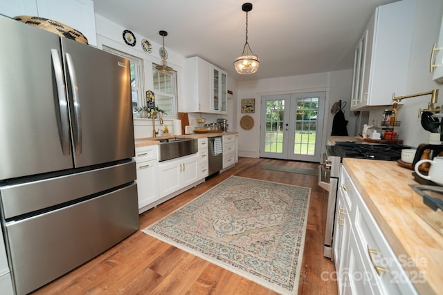 1712 Umstead St, Charlotte, NC 28205 - kitchen with stainless steel appliances, wooden counters, french doors, white cabinets, and glass insert cabinets