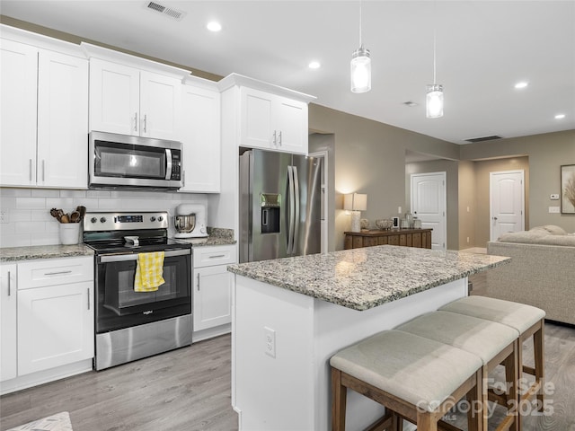 226 Oak Brook Ln Unit 21, Gaffney, SC 29341 - kitchen with stainless steel appliances, open floor plan, light wood-style flooring, a center island, and white cabinetry