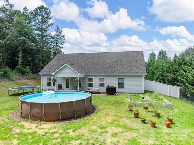 226 Oak Brook Ln Unit 21, Gaffney, SC 29341 - back of house with a trampoline, a garden, an outdoor pool, and roof with shingles