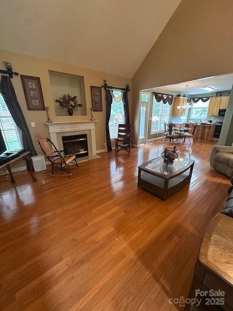 104 Whimbrel Ln, Mooresville, NC 28117 - living room featuring a fireplace with flush hearth, healthy amount of natural light, light wood finished floors, and high vaulted ceiling