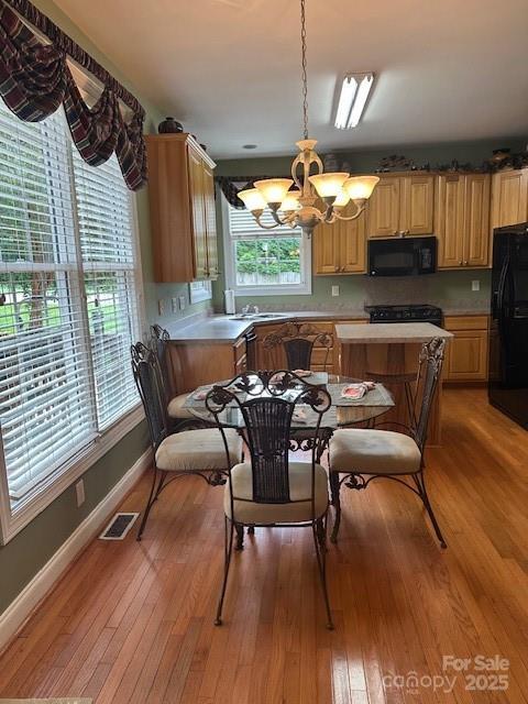 104 Whimbrel Ln, Mooresville, NC 28117 - kitchen featuring black appliances, a chandelier, light wood-type flooring, and light countertops