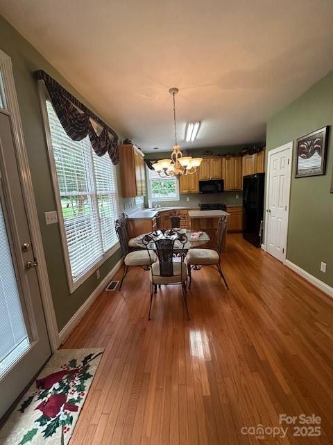 104 Whimbrel Ln, Mooresville, NC 28117 - dining space featuring a chandelier, healthy amount of natural light, and wood finished floors