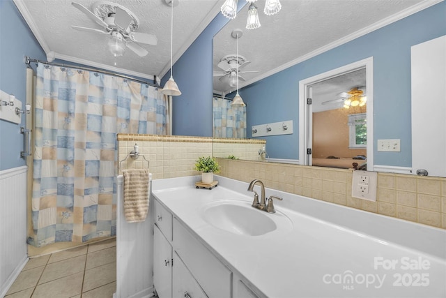 116 Eastwood Park Dr SE, Lenoir, NC 28645 - bathroom with ceiling fan, tile patterned flooring, vanity, a wainscoted wall, and crown molding