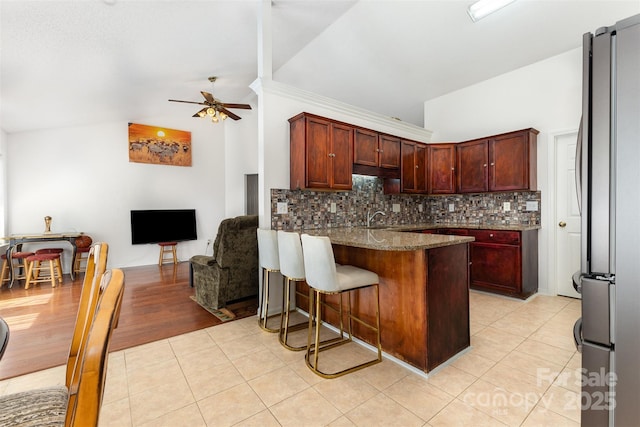 2916 Northwood Dr, Monroe, NC 28110 - kitchen with freestanding refrigerator, vaulted ceiling, ceiling fan, tasteful backsplash, and a peninsula