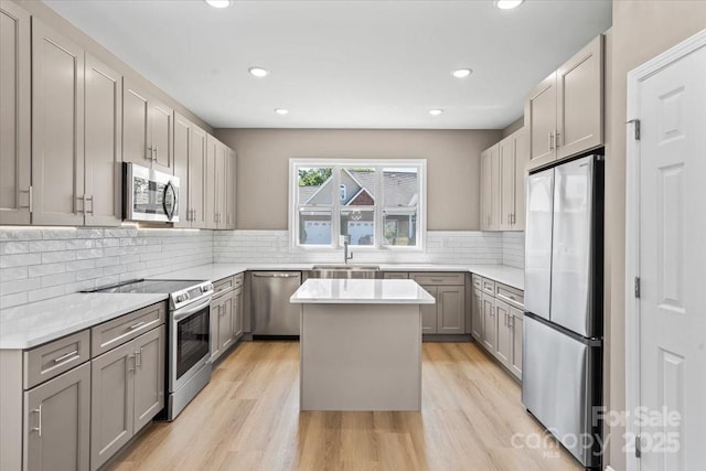 1033 12th Avenue Dr NW, Hickory, NC 28601 - kitchen with stainless steel appliances, gray cabinets, a center island, light wood-type flooring, and light countertops