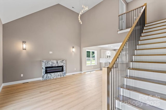 1033 12th Avenue Dr NW, Hickory, NC 28601 - unfurnished living room featuring a fireplace, high vaulted ceiling, wood finished floors, and stairs