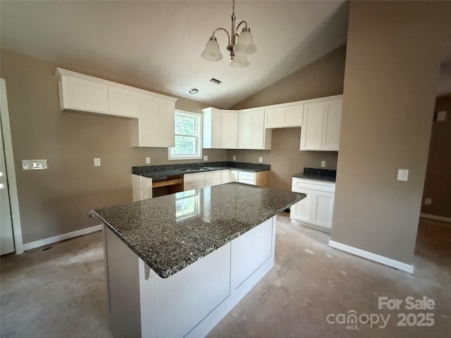 105 Elk Creek Ln, Hudson, NC 28638 - kitchen featuring concrete floors, a chandelier, vaulted ceiling, and white cabinets