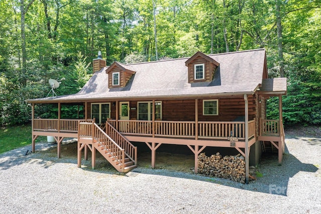28 Upper Ridge Rd, Black Mountain, NC 28711 - view of front of house with a chimney, stairs, a porch, log siding, and a forest view