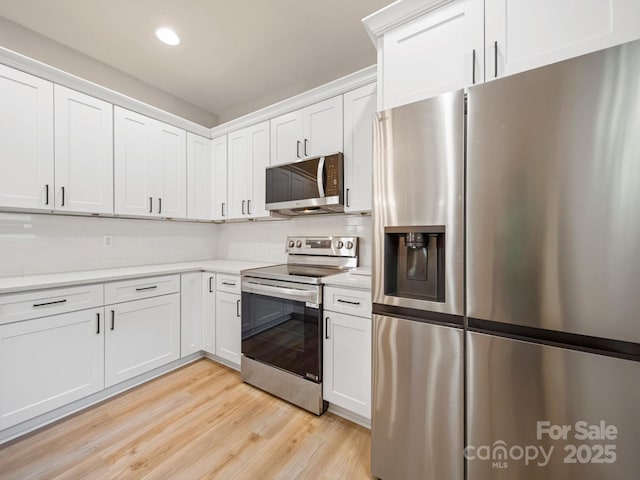8516 Paw Valley Ln, Charlotte, NC 28214 - kitchen featuring appliances with stainless steel finishes, light countertops, backsplash, white cabinets, and light wood-style flooring