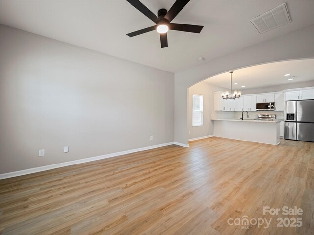 8516 Paw Valley Ln, Charlotte, NC 28214 - unfurnished living room with ceiling fan, arched walkways, a chandelier, light wood finished floors, and recessed lighting