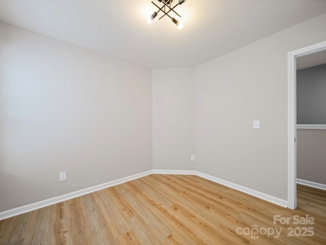 8516 Paw Valley Ln, Charlotte, NC 28214 - unfurnished room featuring wood finished floors and a chandelier