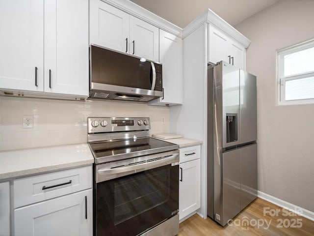 8516 Paw Valley Ln, Charlotte, NC 28214 - kitchen with appliances with stainless steel finishes, white cabinets, light wood-type flooring, backsplash, and light stone counters