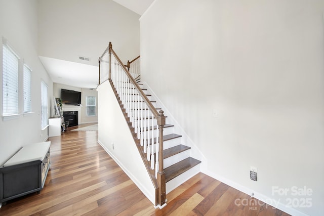 2203 Whitford Ln, Charlotte, NC 28210 - staircase with wood finished floors, a fireplace, and high vaulted ceiling