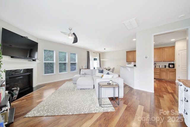 2203 Whitford Ln, Charlotte, NC 28210 - living area featuring light wood-style flooring, a glass covered fireplace, recessed lighting, and a ceiling fan