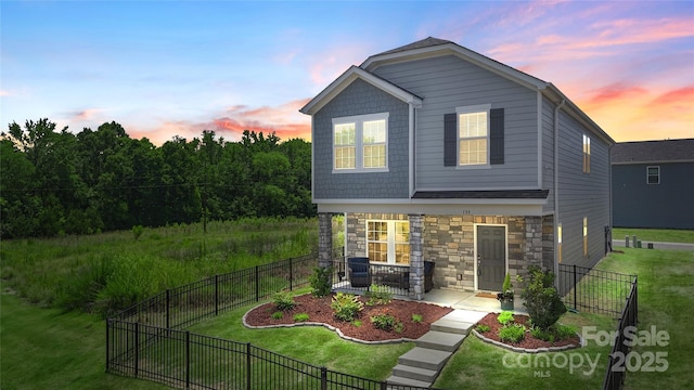135 Orson Oaks Ln, Pineville, NC 28134 - back of property at dusk with stone siding and a fenced backyard
