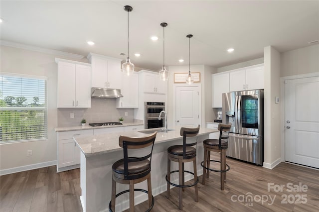 135 Orson Oaks Ln, Pineville, NC 28134 - kitchen with stainless steel appliances, under cabinet range hood, white cabinets, recessed lighting, and crown molding
