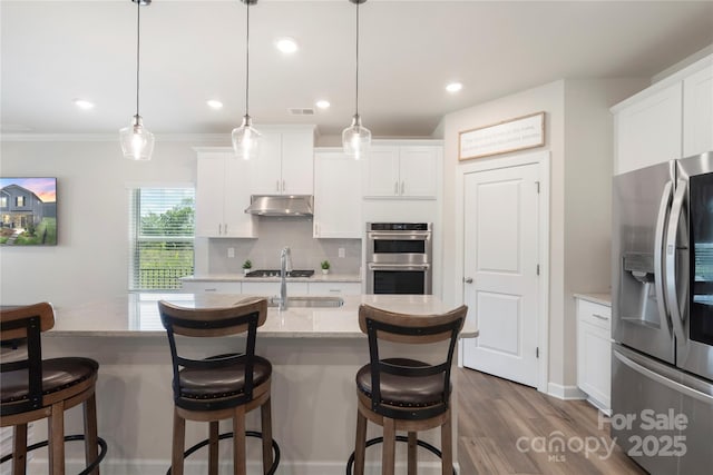 135 Orson Oaks Ln, Pineville, NC 28134 - kitchen featuring appliances with stainless steel finishes, under cabinet range hood, backsplash, white cabinets, and dark wood-type flooring