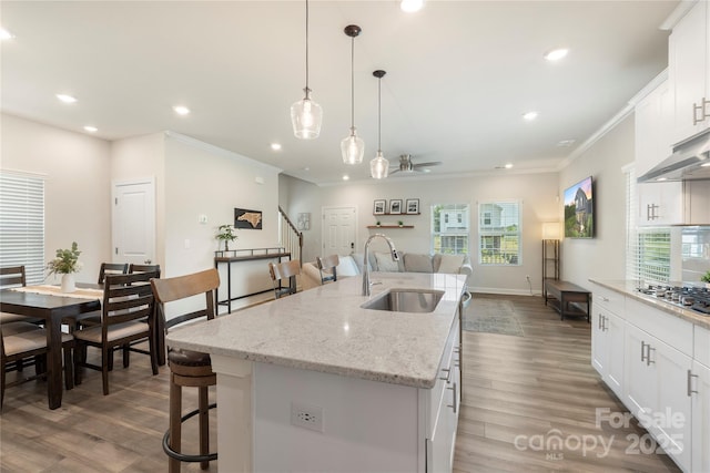 135 Orson Oaks Ln, Pineville, NC 28134 - kitchen with recessed lighting, healthy amount of natural light, white cabinetry, crown molding, and a kitchen island with sink