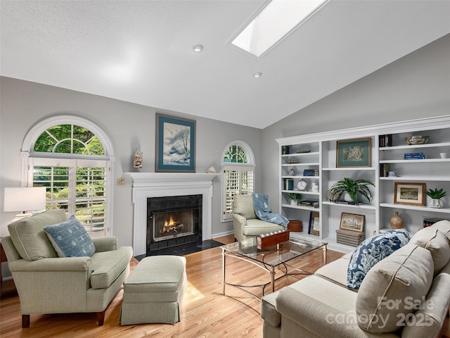 189 Cove Loop Rd, Hendersonville, NC 28739 - living area featuring a fireplace with flush hearth, lofted ceiling, wood finished floors, a skylight, and recessed lighting