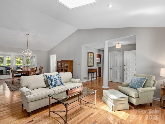 189 Cove Loop Rd, Hendersonville, NC 28739 - living room featuring decorative columns, lofted ceiling, light wood-style floors, and a chandelier