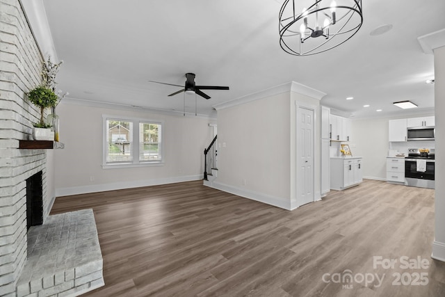 7219 Spring Morning Ln, Charlotte, NC 28227 - unfurnished living room featuring a fireplace, ornamental molding, wood finished floors, stairs, and recessed lighting