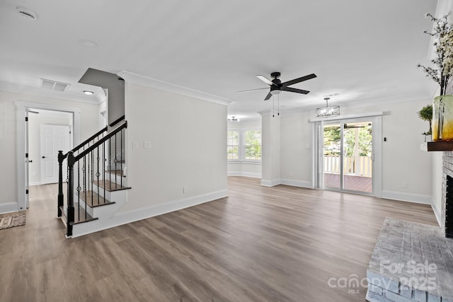7219 Spring Morning Ln, Charlotte, NC 28227 - unfurnished living room featuring ceiling fan, a brick fireplace, stairway, wood finished floors, and ornamental molding