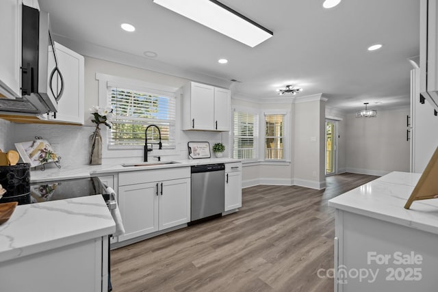 7219 Spring Morning Ln, Charlotte, NC 28227 - kitchen featuring appliances with stainless steel finishes, ornamental molding, plenty of natural light, recessed lighting, and white cabinetry