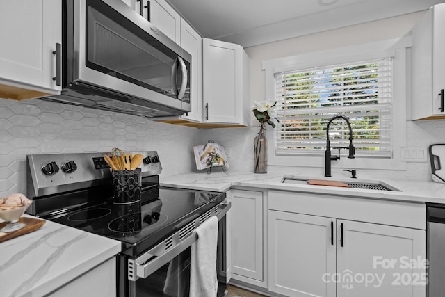 7219 Spring Morning Ln, Charlotte, NC 28227 - kitchen featuring stainless steel appliances, backsplash, white cabinets, and light stone countertops
